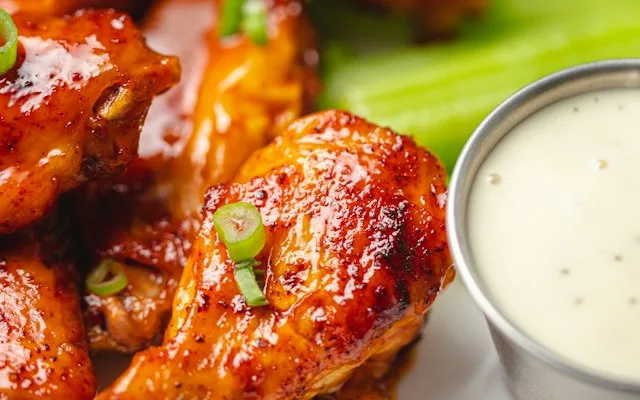 Ailes de poulet laquées à la sauce barbecue avec une sauce blanche