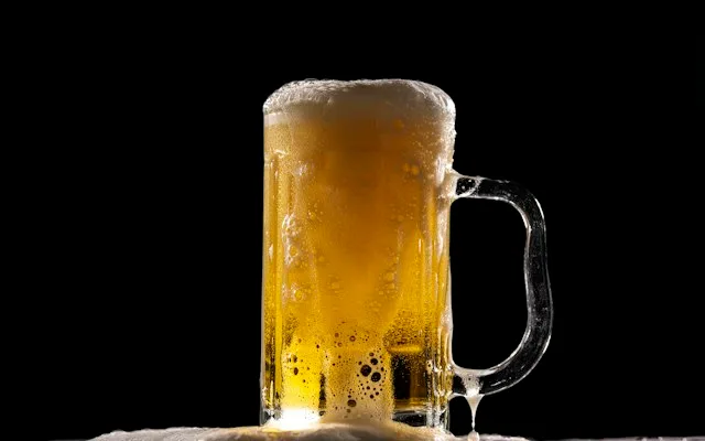 Chope de bière mousseuse sur fond noir