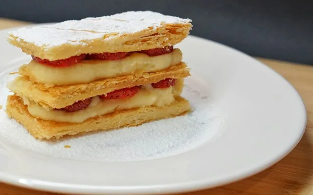 Part de mille-feuille sur une assiette blanche