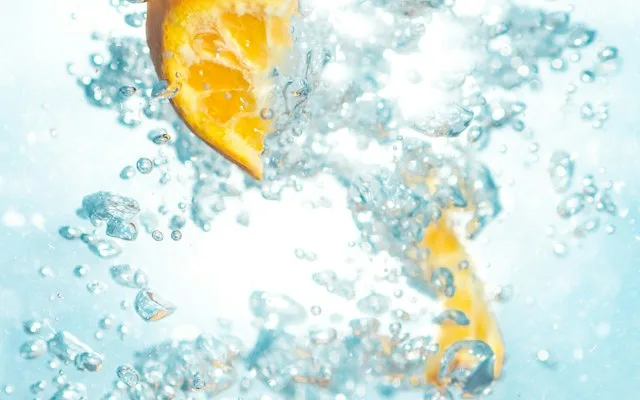 Bulles dans une eau pétillante avec une tranche d’orange