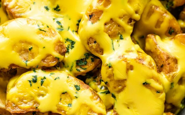 Fromage fondu coulant sur des pommes de terre