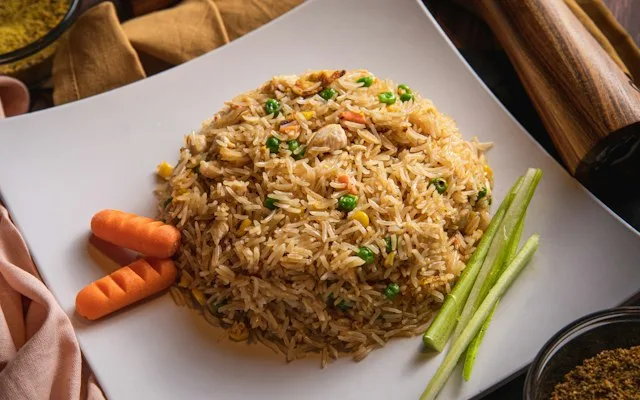Riz frit aux petits pois et aux carottes sur une assiette blanche