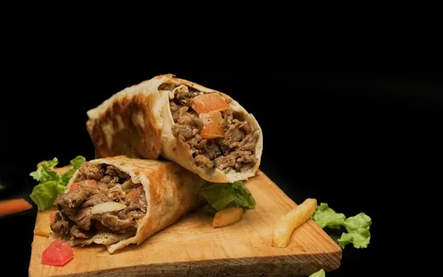 Galette roulée et grillée garnie de viande, coupée en deux