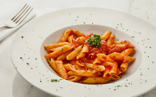 Penne à la sauce tomate dans une assiette creuse